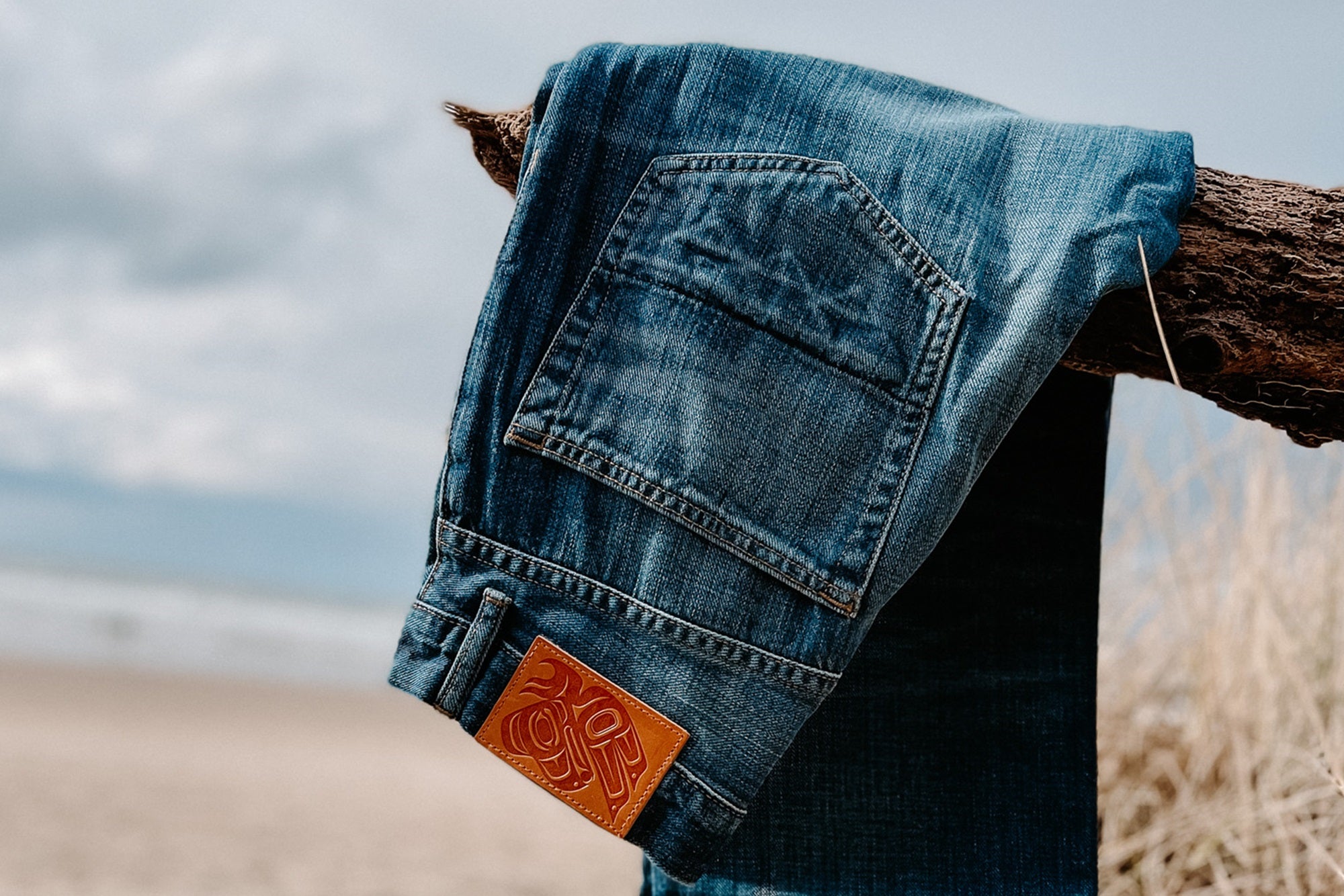 Made in USA denim jean by Ginew on branch at beach